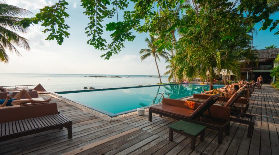 brown wooden table and chairs on brown wooden deck near body of water during daytime